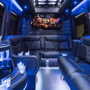 limousine style Mercedes Sprinter party bus with bench style seating, party lights, built in bar and champagne glasses