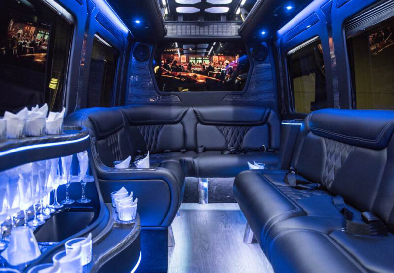 limousine style Mercedes Sprinter party bus with bench style seating, party lights, built in bar and champagne glasses