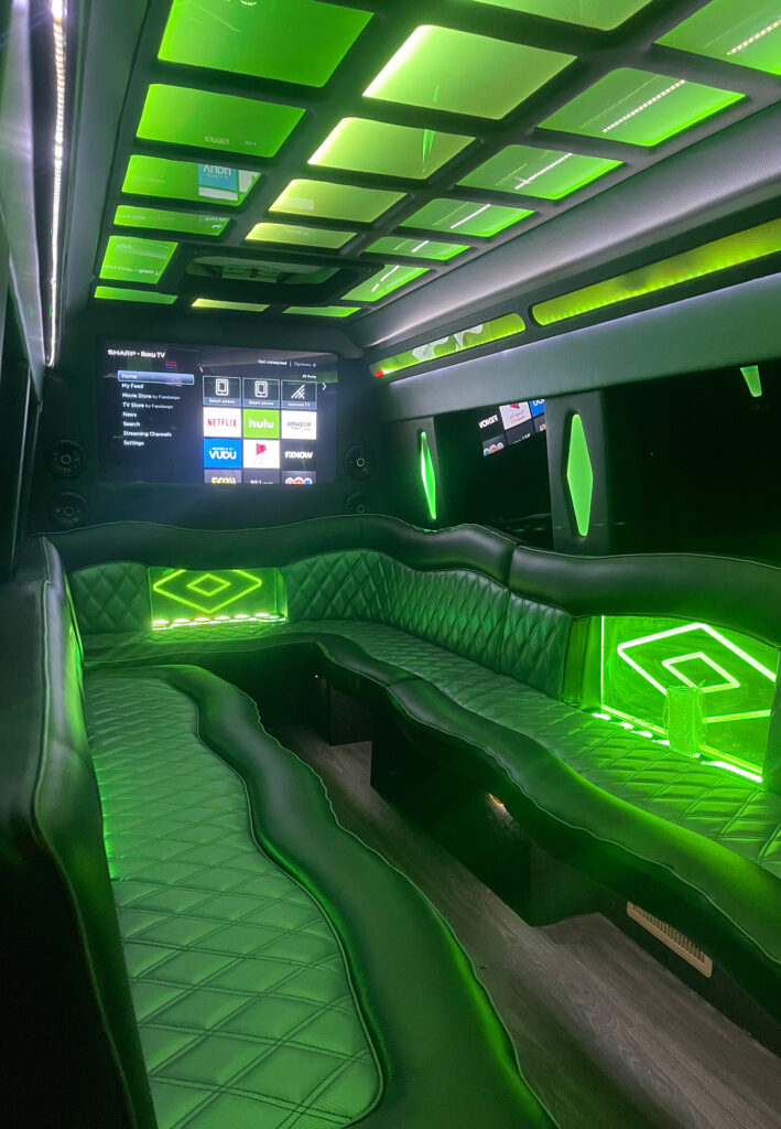 Sprinter Limo interior with wet bar, smart TV, accent lighting and leather bench seating