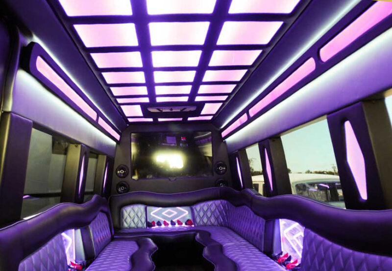 Mercedes limo bus interior with accent lighting, wet bar, smart TV and u shaped limousine bench seating