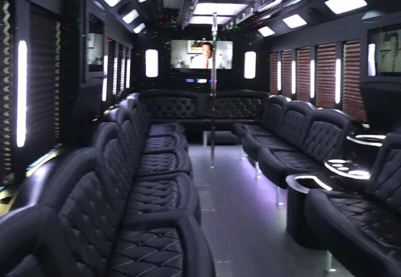 dance pole in party bus with limousine bench seating and wet bar and party lights