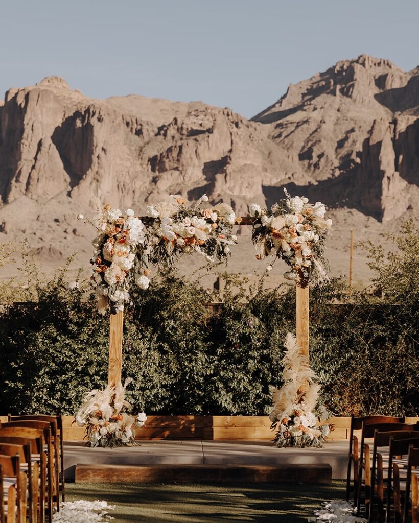 Floral archway with mountain views in the background at a ceremony at the Paseo